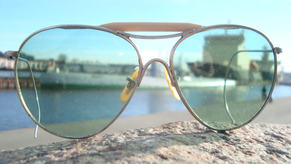 A pair of sunglasses on a beach Description automatically generated with medium confidence
